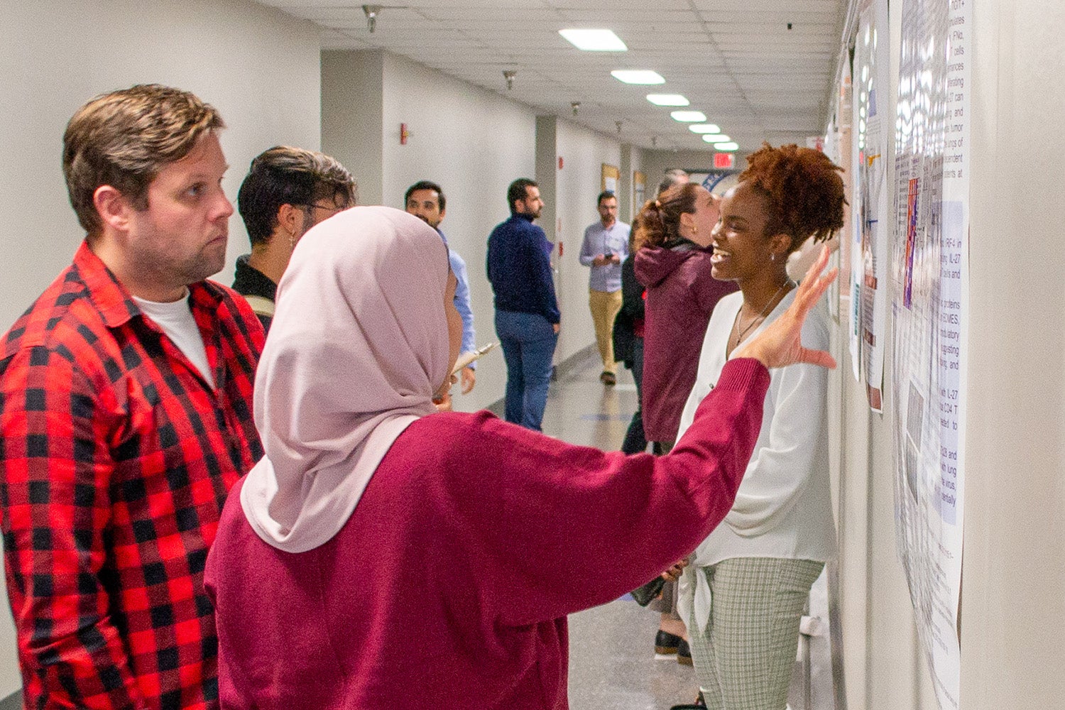 Students discuss their research posters at Student Research Day.